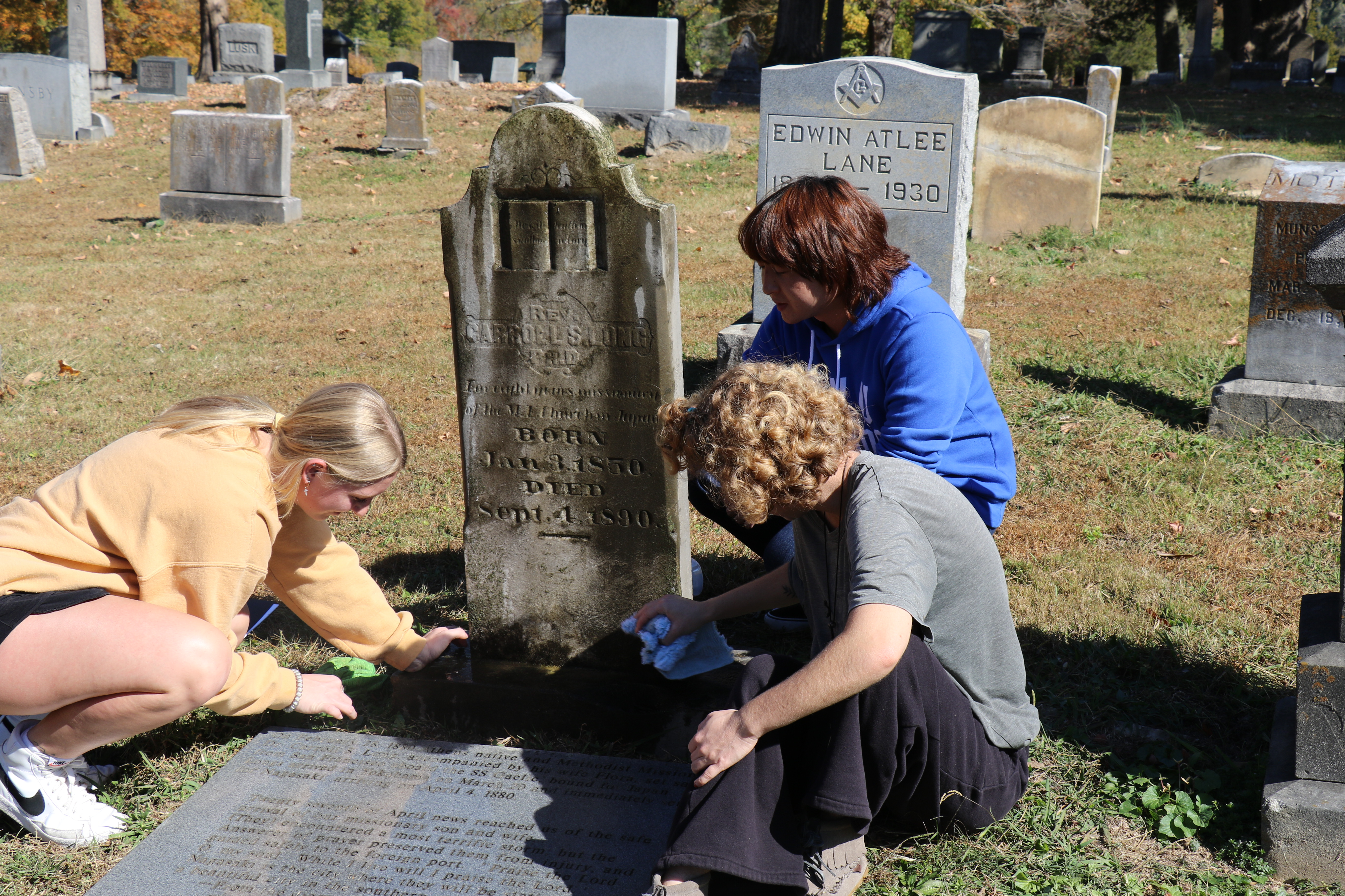 Johny, Josie, and Chloe cleaning Rev. Dr. Long's tombstone 