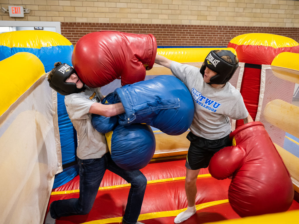 Two male students play boxing at Bulldog Bash