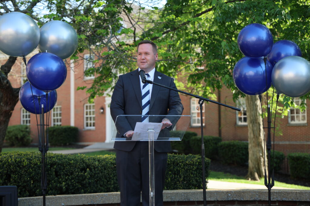 Tyler Forrest stands at the podium to welcome those in attendance