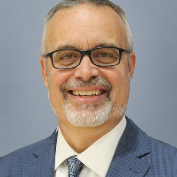 Smiling middle-aged man with gray hair and glasses in a blue suit and tie (professional headshot).