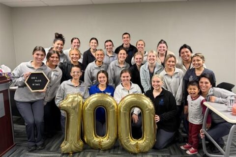 Dental hygiene students pose with balloons that make a "100"