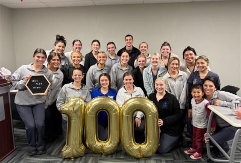 Dental hygiene students pose with balloons that make a "100"