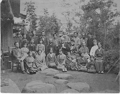 | Tennessee Wesleyan University Historic black-and-white group photo of men, women, and children posing outdoors in a garden setting.