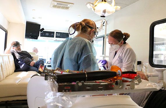 Dental Hygiene students working on patient in mobile clinic