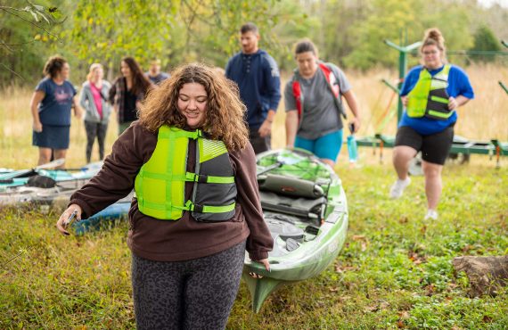 Young lady carrying a kayak
